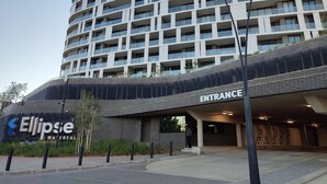 A multi-story hotel with a modern design, featuring a prominent entrance and a sign for 'Ellipse Waterfall.'