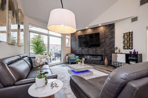 Living area - Newly renovated 2,000 sq ft penthouse loft at Discovery Bay. Sleeps 12 with 4 bedrooms, new kitchen, 3 full baths, custom stone media wall, and glass loft wall. Lake views, steps to beach, plus pools, gym, hot tub, games room & 2 secured parking stal (Kelowna)