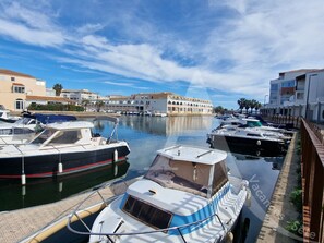 A marina with boats docked, a clear sky, and buildings in the background. - 111 / T2 PROCHE MER AVEC LOGGIA (Sète)