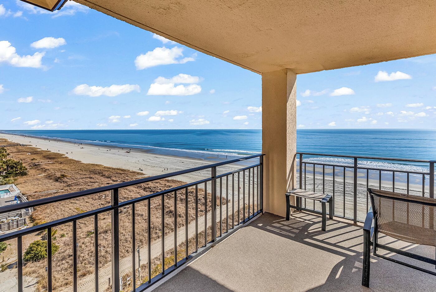 A balcony with a view of a beach and ocean.