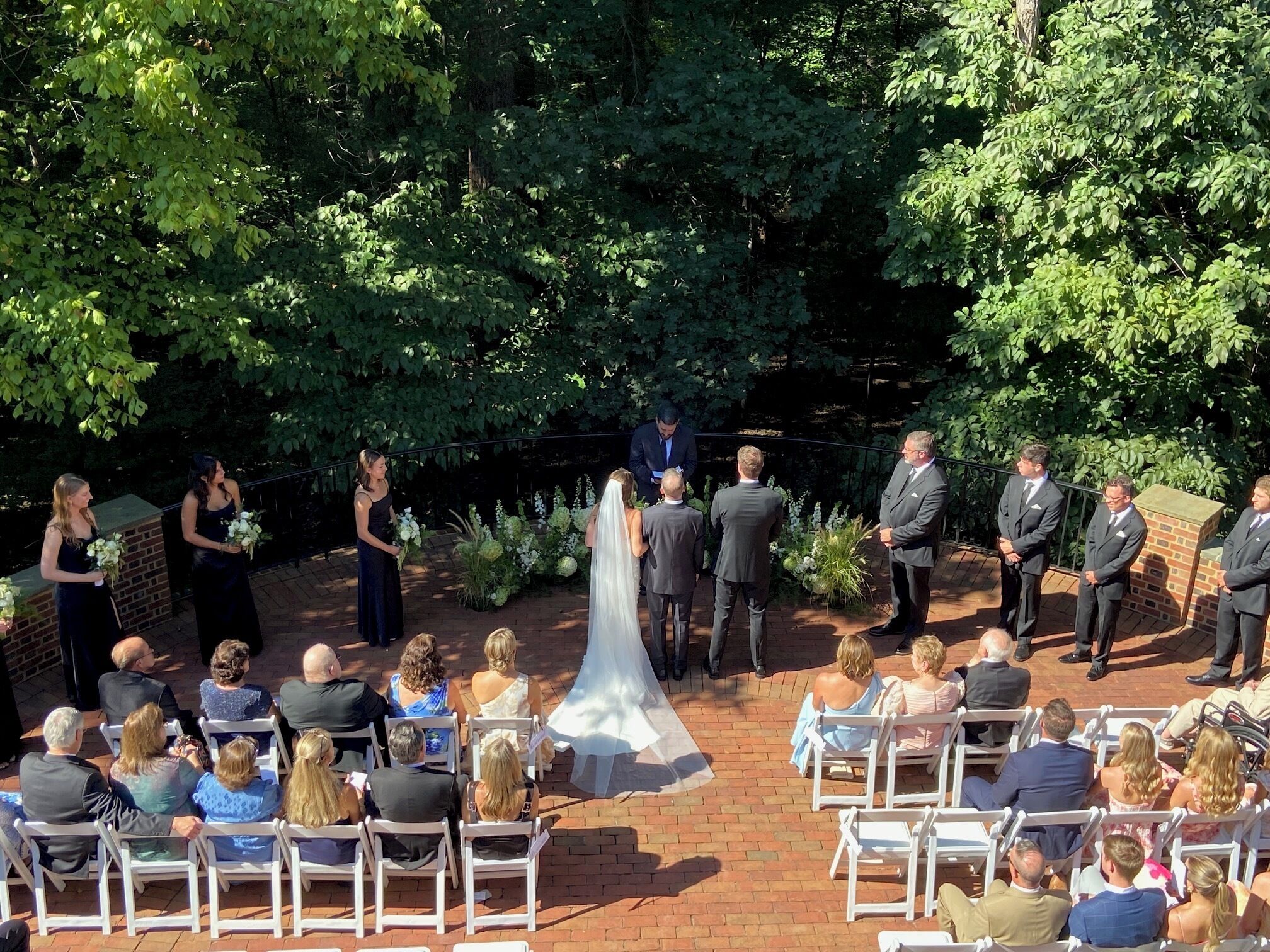 A wedding ceremony outdoors with guests seated in rows.