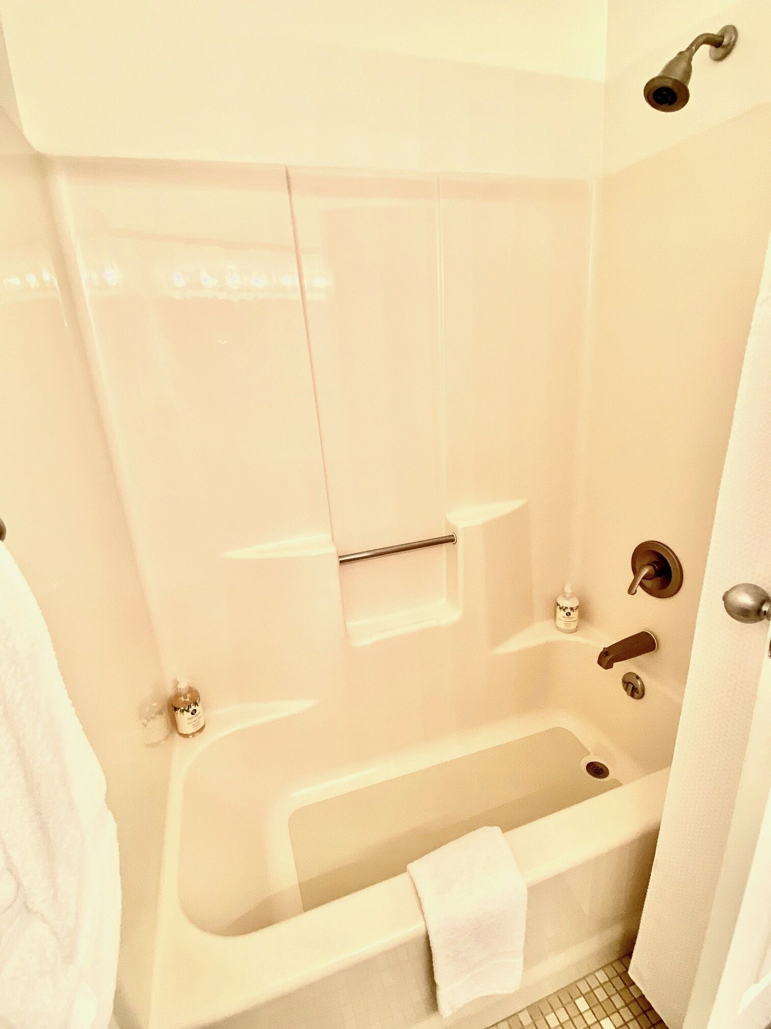 Une salle de bain équipée d’une baignoire, d’une douche, d’un porte-serviettes et de toilettes.