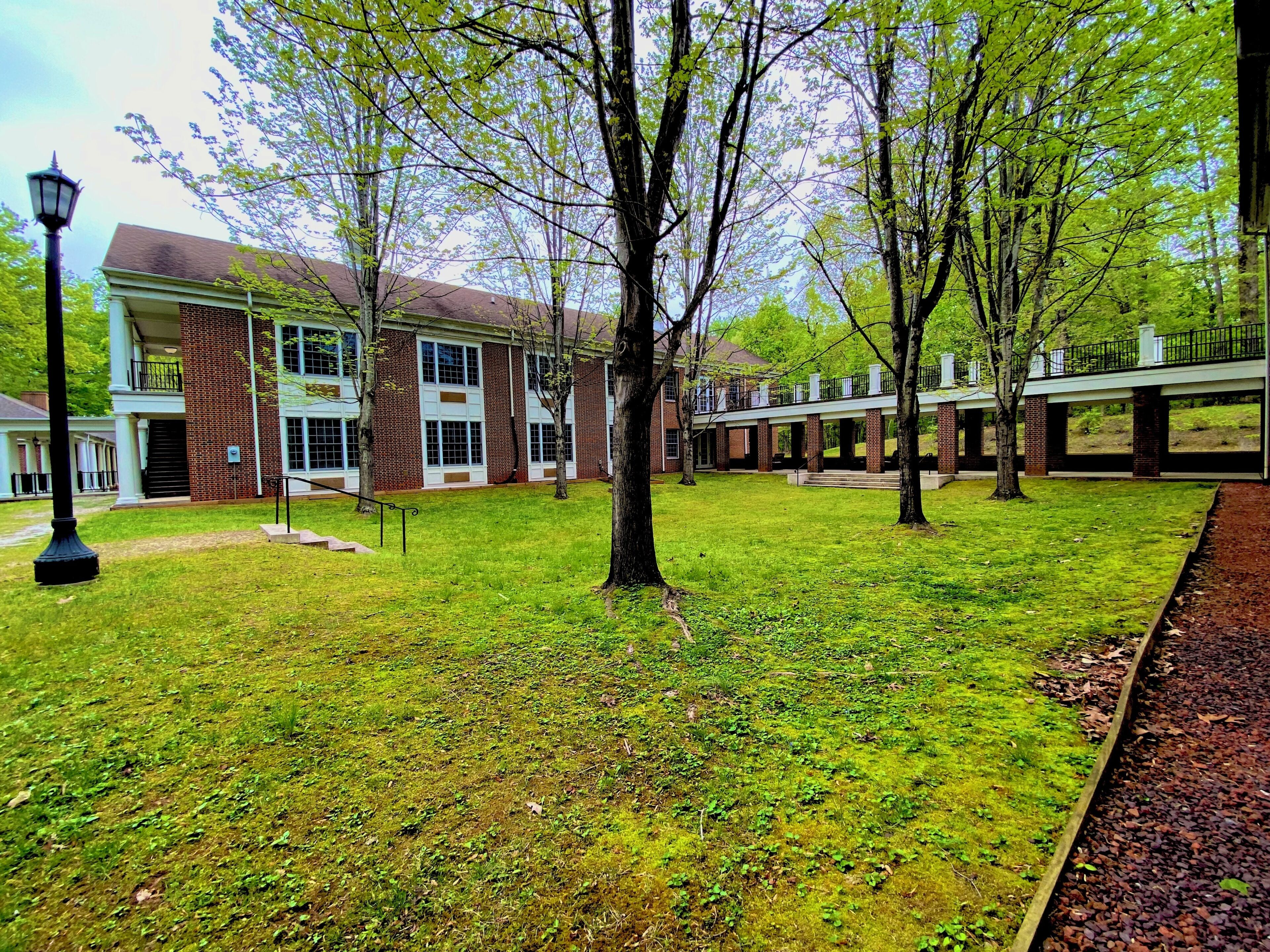 A building with a brick facade, large windows, and a covered walkway.