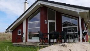 Moderni talo, jonka ulkoseinät ovat punaiset, siinä on suuret ikkunat ja selvästi näkyvässä paikassa numero 115.