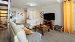 A modern living room with a sofa, coffee table, TV, and a staircase. - Independent Villa in Exclusive Chayofa, Near Los Cristianos and Siam Park (Chayofa)