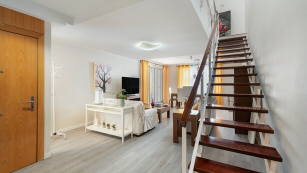 A staircase leading to a second floor, a living area with a TV, a dining table, and a sofa. - Independent Villa in Exclusive Chayofa, Near Los Cristianos and Siam Park (Chayofa)