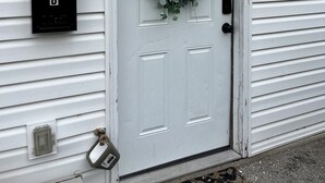 A white door with a wreath, a mailbox, and a utility box on the siding. - Newly Furnished St. Charles Getaway- B (Saint Charles)