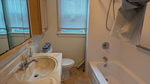 Une salle de bain avec un lavabo, des toilettes et une baignoire.