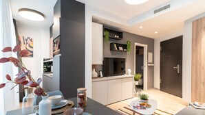 Uma sala moderna com área de refeições, cozinha e porta de madeira.