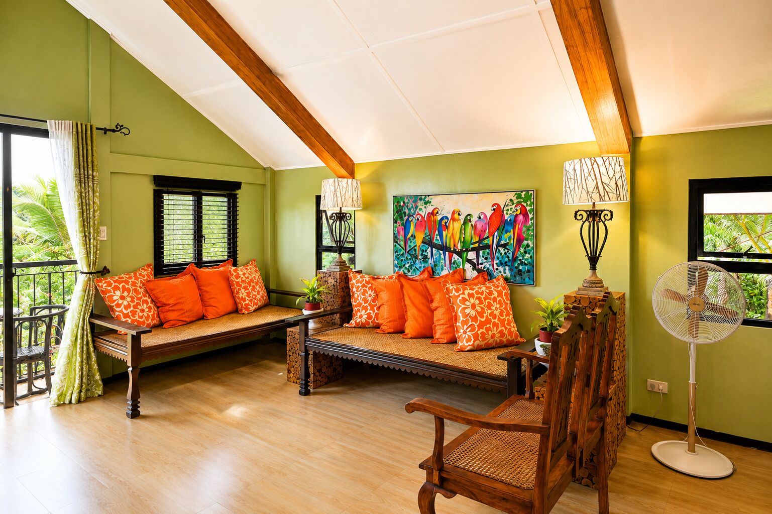 A room with a wooden bench, a chair, a fan, and a painting of colorful birds.