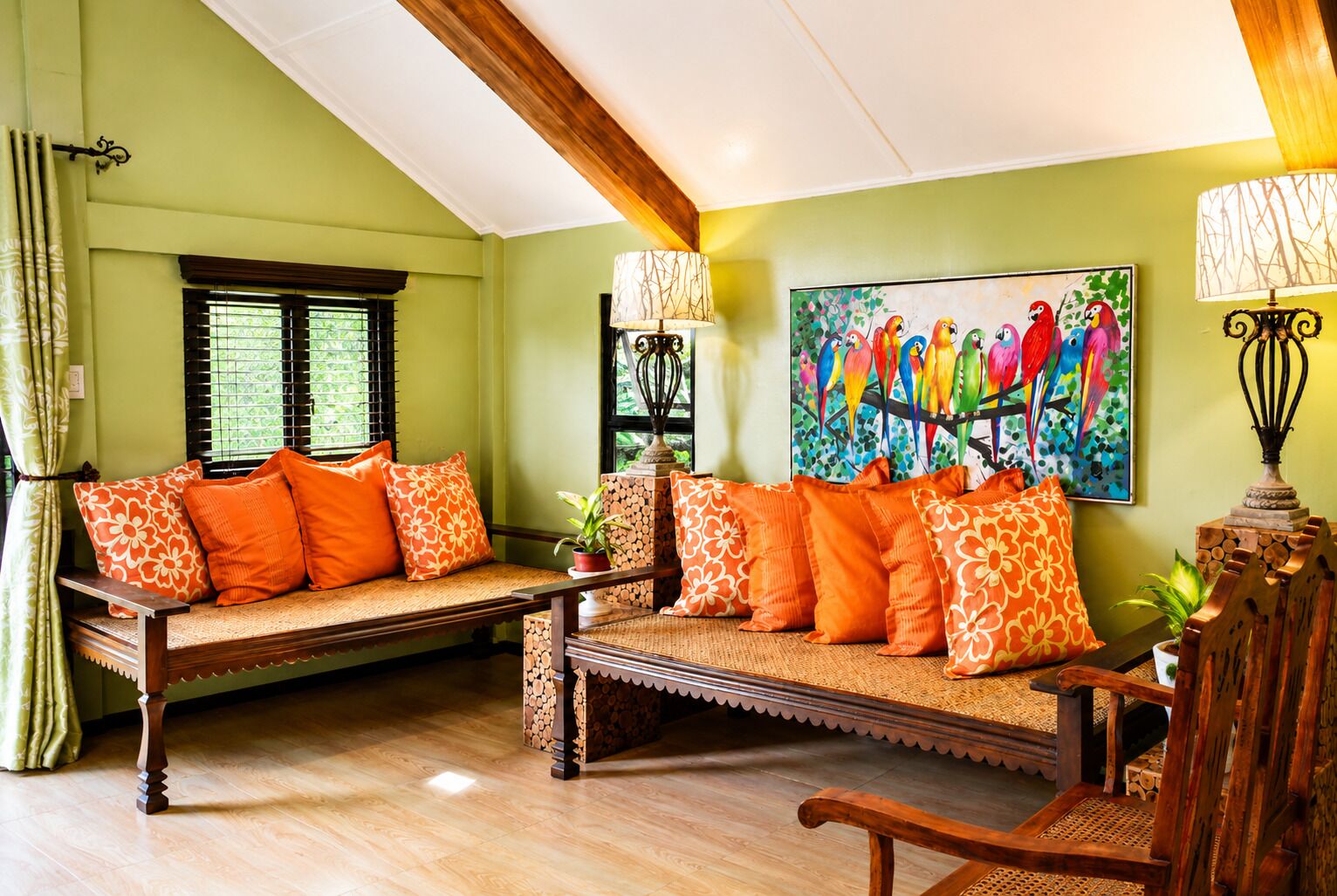 Una habitación con un banco de madera, un sofá con cojines naranjas, un cuadro de aves coloridas y una lámpara con diseño de árbol.