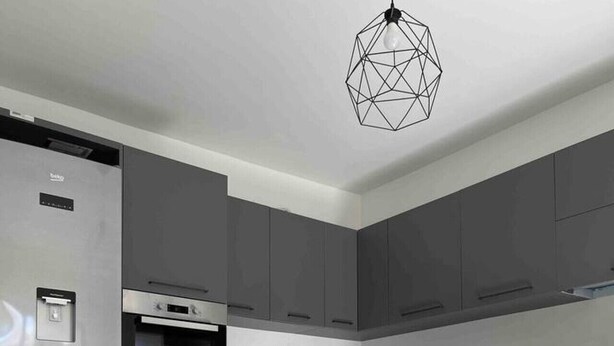A modern kitchen with grey cabinets, a stainless steel refrigerator, a built-in oven, and a dining area with a table and chairs. - Zen Apt in the Heart of Malta (Ta` Xbiex)