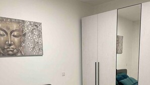 A bedroom with a bed, a wardrobe, and a wall-mounted artwork. - Zen Apt in the Heart of Malta (Ta` Xbiex)