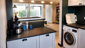 Eine kleine Küche mit Kaffeemaschine, Toaster und Waschmaschine.