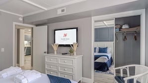 Ein Schlafzimmer mit einem Bett, einem Fernseher, einem Kleiderschrank und einem Sessel.