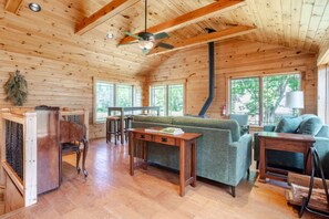 A wooden cabin interior with a sofa, a table, and a ceiling fan. - East Branch Nature House - Spring Water Retreat (East Branch)