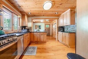 A kitchen with wooden cabinets, a stove, and a refrigerator. - East Branch Nature House - Spring Water Retreat (East Branch)