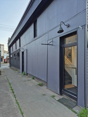 A modern building with a flat facade, large windows, and a visible entrance.