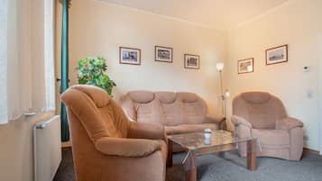 Una habitación acogedora con dos sillones, una mesita de centro y una planta.
