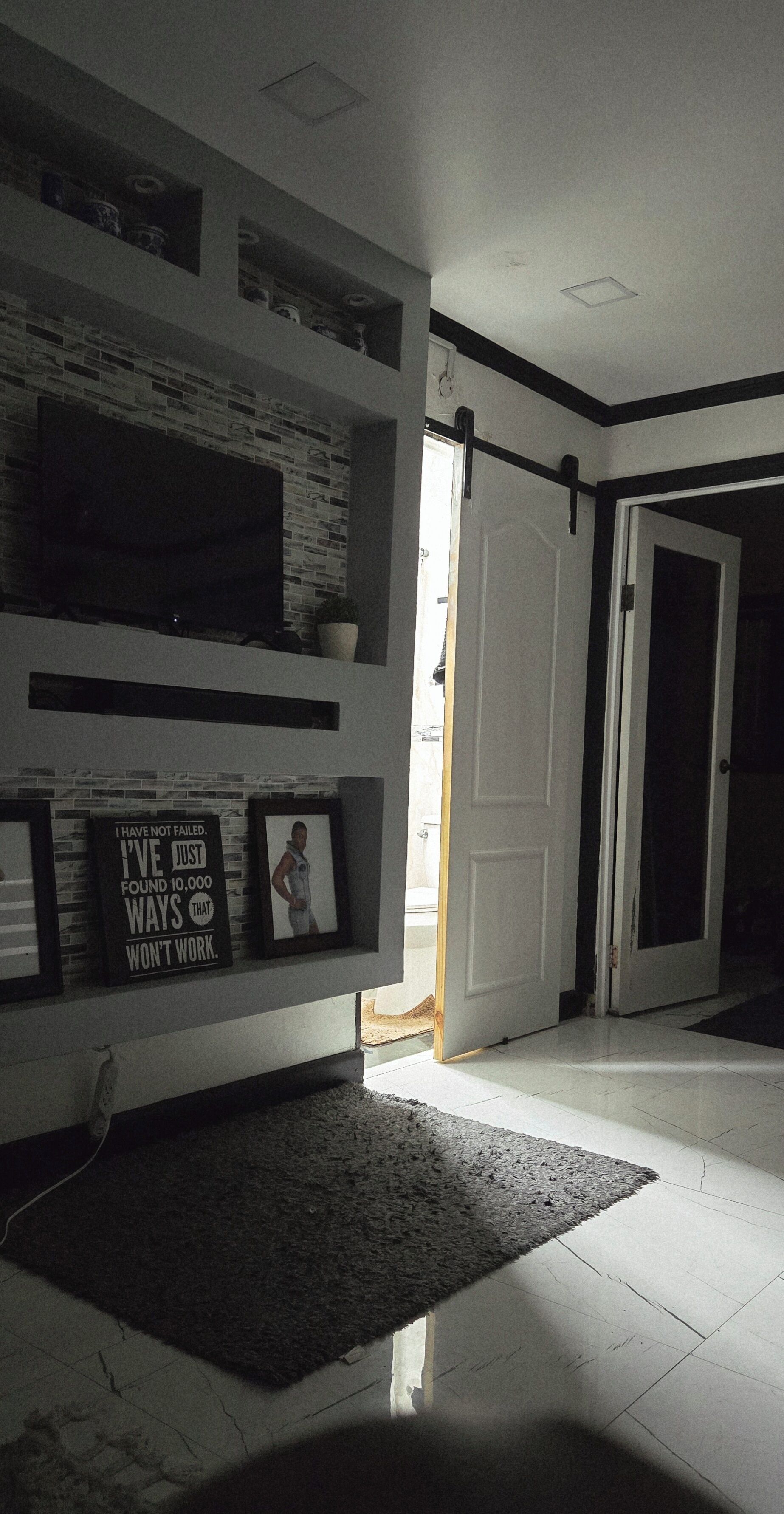 A living room with a fireplace, a flat-screen TV, and a motivational quote on the wall.