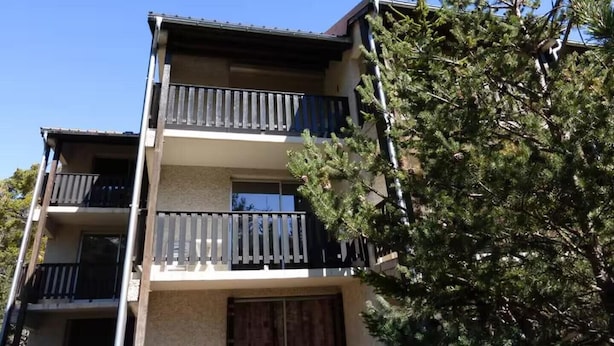 A multi-story building with balconies and a tree in the foreground. - Mountain views and comfort near Barcelonnette (Enchastrayes)