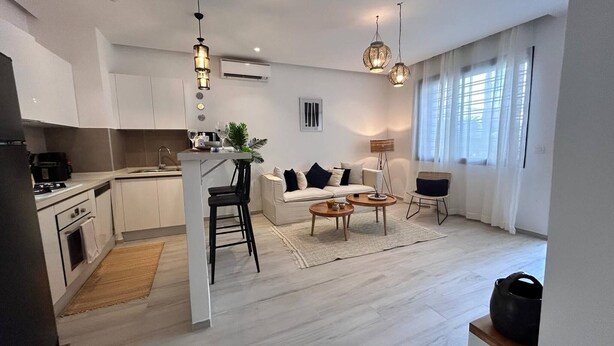 Een modern appartement met keuken, eethoek en woonkamer.