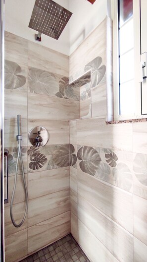 A shower with a handheld showerhead and a wall-mounted faucet, surrounded by patterned tiles. - La Dimora Di Monica - Lavanda (Morciano di Leuca)
