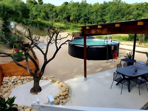 An outdoor patio with a hot tub, seating area, and a tree. - Le gîte des cigales de Lucéna – Cozy Retreat with Pool in Provençal Vineyard (Visan)