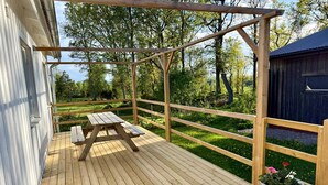 A wooden deck with a picnic table and a potted plant. - Rural charm and modern comfort – close to nature and swimming |SE08016 (Ljung)