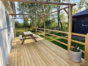 A wooden deck with a picnic table and a potted plant. - Rural charm and modern comfort – close to nature and swimming |SE08016 (Ljung)