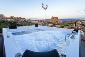 Un bain à remous offrant une vue sur un paysage rocheux et des bâtiments.