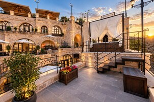 Un edificio de piedra con mesas al aire libre y una escalera.