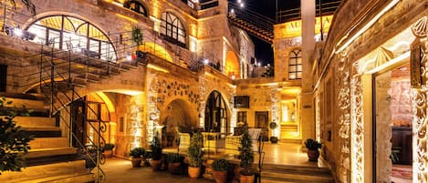 A historic building with multiple levels, stone arches, and a staircase leading to an upper floor.