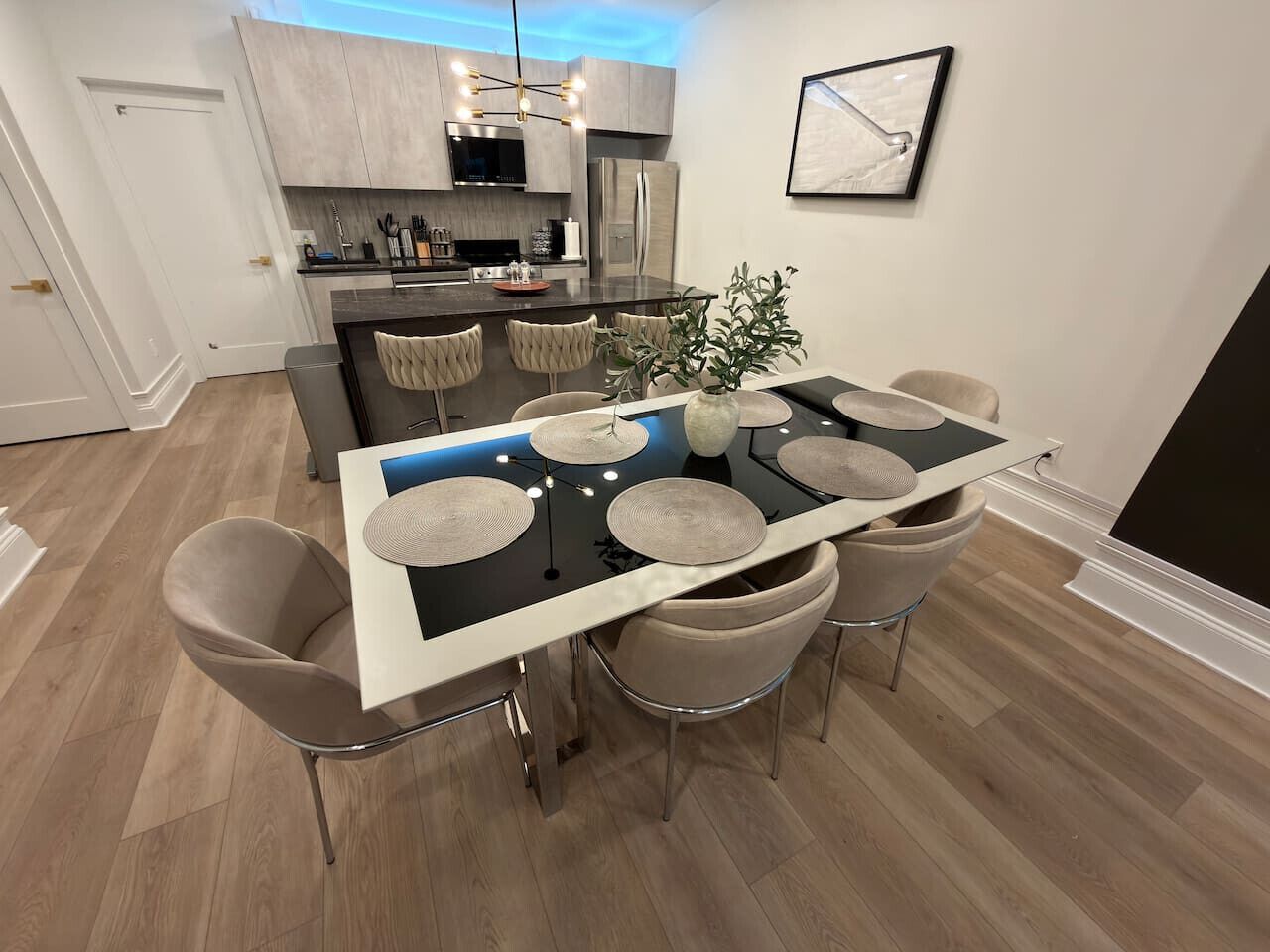 Un espace repas moderne avec un îlot central, un revêtement de sol en bois clair et un mobilier contemporain.