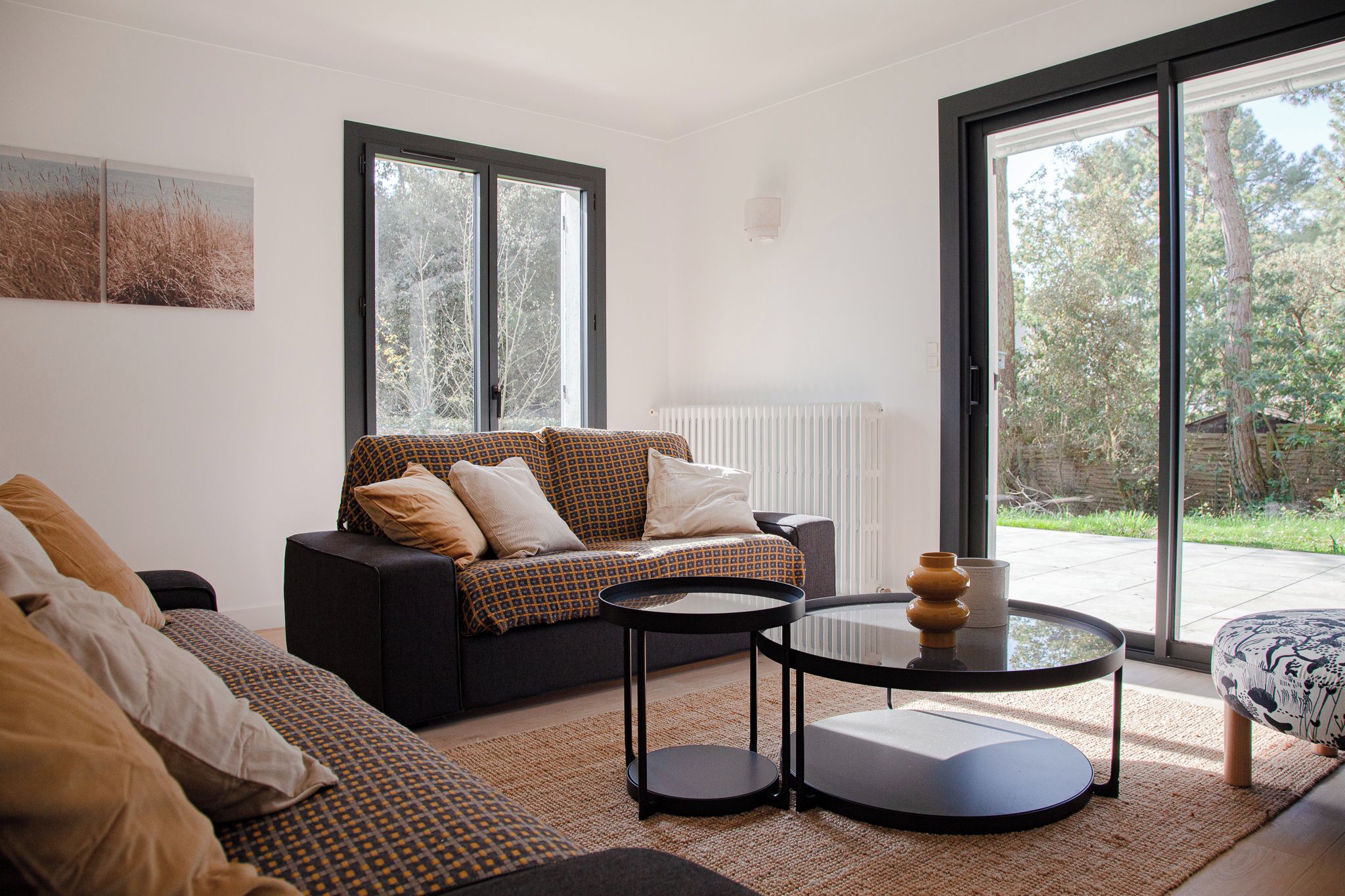 Un salon moderne avec un canapé, une table basse et une vue sur l’extérieur.