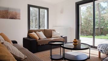 Un salon moderne avec un canapé, une table basse et une vue sur l’extérieur.
