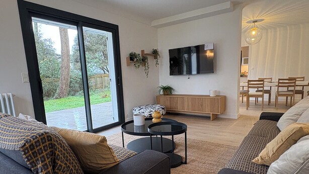 A modern living room with a sofa, a coffee table, and a TV mounted on the wall. - Premium villa, enclosed garden, games room. (La Baule-Escoublac)