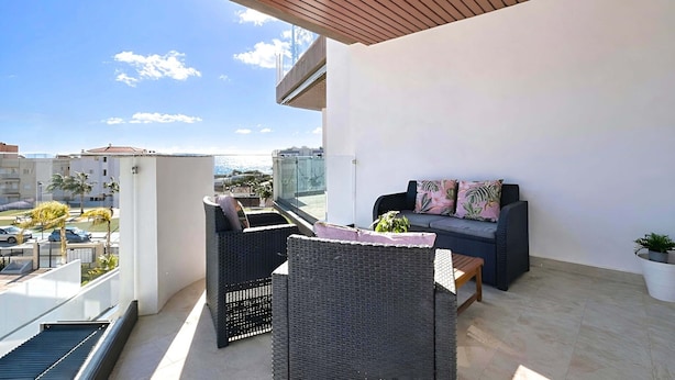 A balcony with wicker furniture, a sofa with cushions, and a potted plant. - Marinsa Gaviota (Torrox)