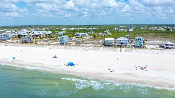 A coastal area with beachfront properties, a sandy beach, and a clear sky. - Rhapsody in Blues (Port St. Joe)