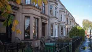 A row of traditional buildings with large windows and a narrow sidewalk. - The West Nest For Six - Pass the Keys (Glasgow)
