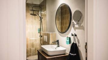 A modern bathroom with a shower, a sink, and two mirrors.