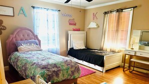 A bedroom with two beds, a desk, and a dresser. - Spacious 4-bedroom house in tranquil Grovetown (Grovetown)