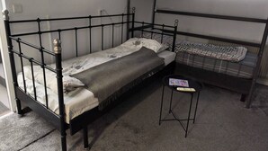A bunk bed room with a small table and a power outlet on the wall. - Room-self Check-in Sun Loft (Halmstad)
