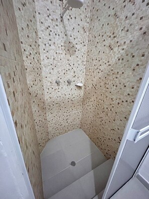 A shower with mosaic tile walls and a white floor. - Hotel Santa Marta's (Popayán)