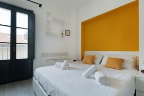 A hotel room with a bed, a window, a white wall, and a yellow accent wall. - GuestHost - Cozy 40m2 apartment, ideal for two, on the third floor of a building with lift.The accommodation is located a stone's throw from Piazza Vetra, a historic district of Milan, located behind the Basilica of San Lorenzo, transformed from a popula (Milan)
