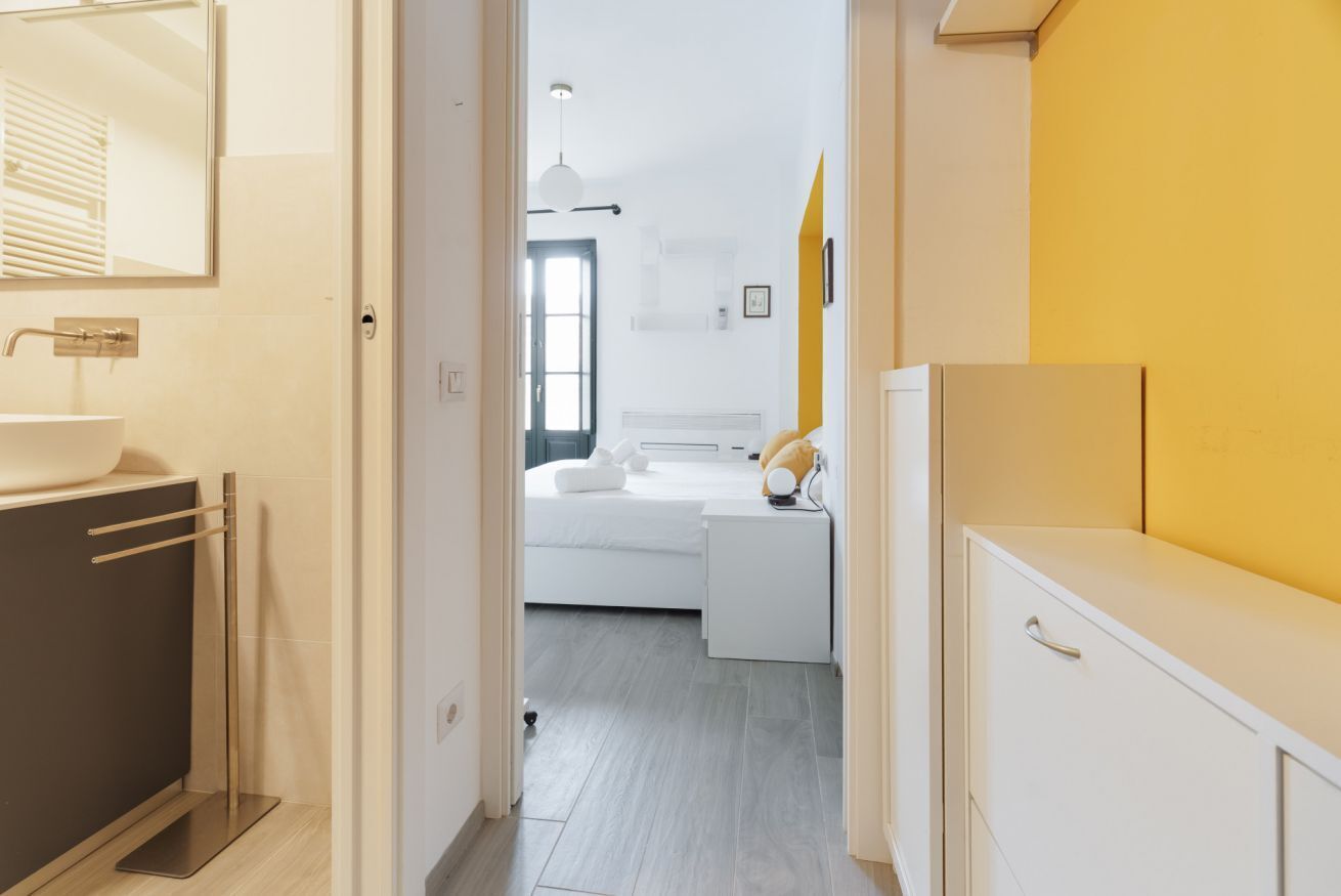 Un bagno moderno con lavandino, specchio e portasciugamani.