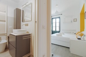A modern bathroom with a large mirror, a sink, and a toilet. - GuestHost - Cozy 40m2 apartment, ideal for two, on the third floor of a building with lift.The accommodation is located a stone's throw from Piazza Vetra, a historic district of Milan, located behind the Basilica of San Lorenzo, transformed from a popula (Milan)