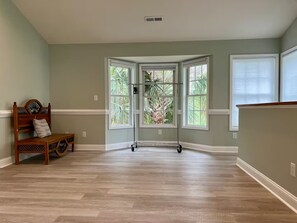 A room with a wooden bench, a large bay window, and a ceiling vent. - Relaxing 1BR Oasis with Dreamy Spa Bathroom (Wilmington)