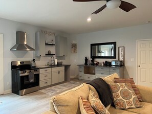 A modern kitchen with a built-in oven, a stove, and a ceiling fan. - Relaxing 1BR Oasis with Dreamy Spa Bathroom (Wilmington)