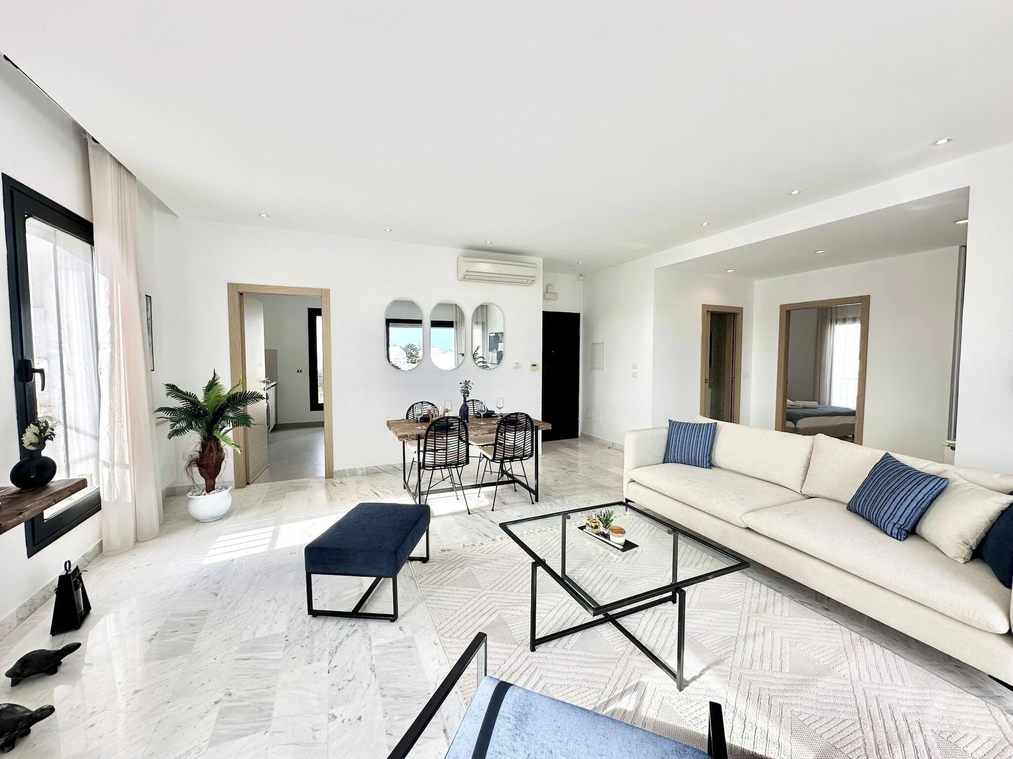 A modern living room with a sofa, coffee table, and dining area.